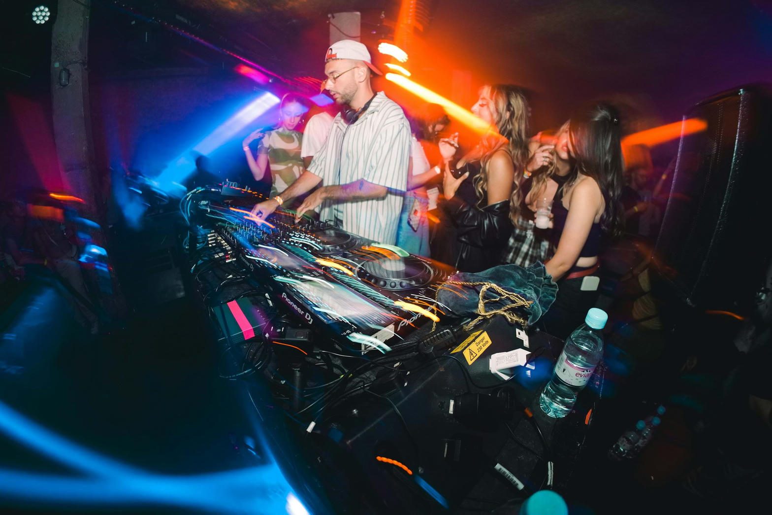 DJ and dancers in a dark club